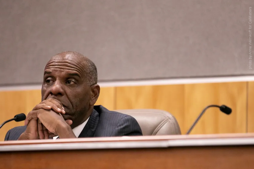 Photograph of California's Senator Bradford, seated at a legislative meeting.